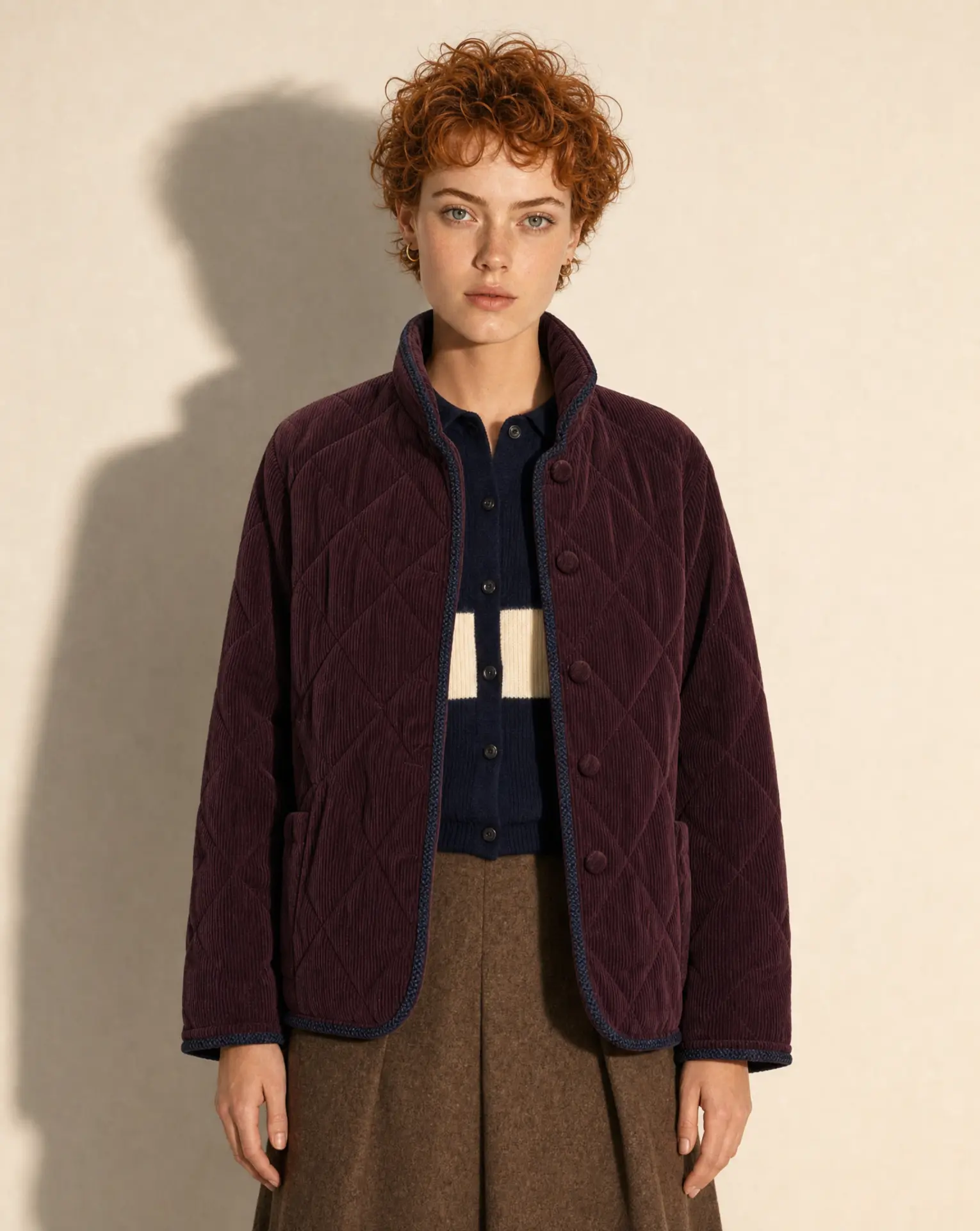 Quilted plum corduroy jacket over navy knit, studio lookbook portrait